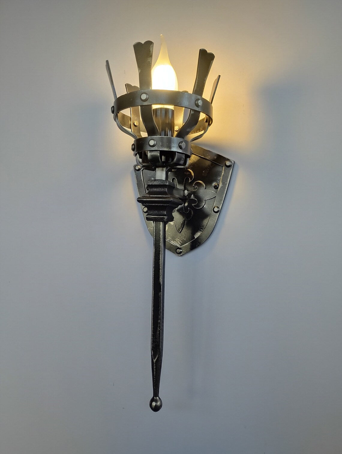Decorative wall light fixture with a unique design on a plain background