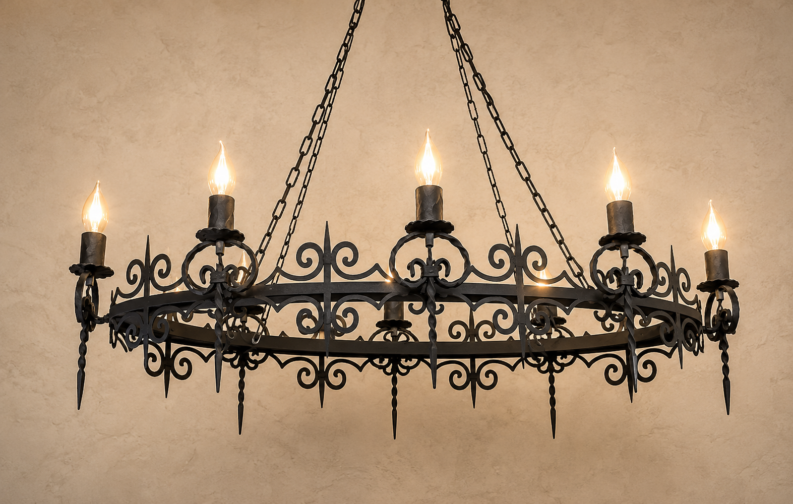 Wrought iron chandelier with candle-style lights on a beige wall.