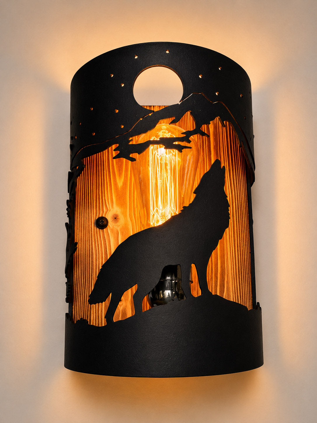 Handcrafted wolf wall light featuring a laser-cut steel howling wolf beneath a full moon with a solid wood back panel for rustic cabins, lodges, and mountain homes.