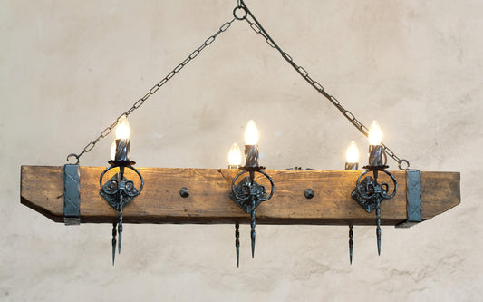 A rustic wood beam and wrought iron chandelier with multiple light bulbs, hanging against an indoor background.