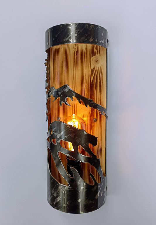 A rustic style wall light featuring a mountain lion design, made out of wood and steel with a burned wood finish on the wood and a clear coat finish on the steel.