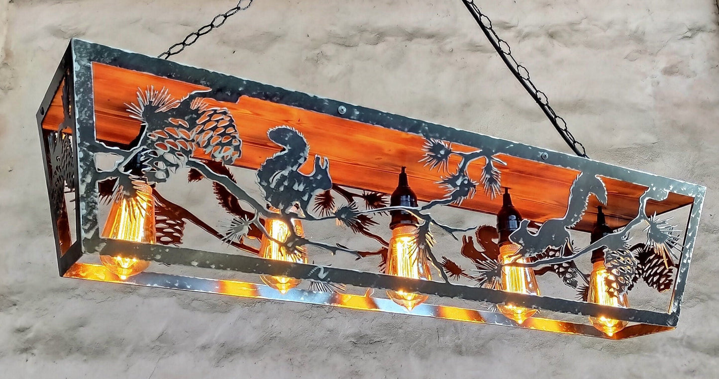 Rustic ceiling light fixture with a redwood-colored panel and a chain of lights hanging from it, featuring a squirrel and pine cone design.