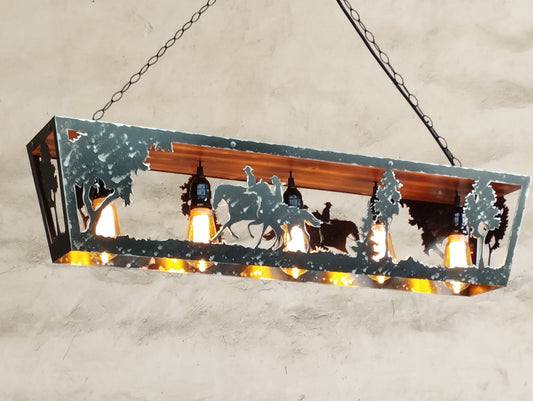 Rustic ceiling-mounted light fixture with a steel frame and wooden elements, featuring a scene with horses. The light is turned on, displaying the silhouette of the horses against a tree backdrop.